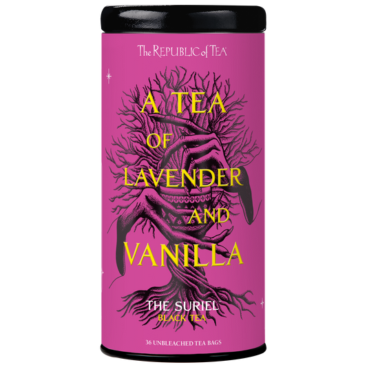 A tea tin canister with a black lid and base, featuring a magenta-pink label with a black illustrated tree and yellow text reading 'A TEA OF LAVENDER AND VANILLA' and 'THE SURIEL BLACK TEA'.